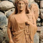 Afrodite con chitone e himation che regge un eros alato, Da Medma terracotta metà del V secolo a.C., Museo Archeologico Nazionale, Reggio Calabria